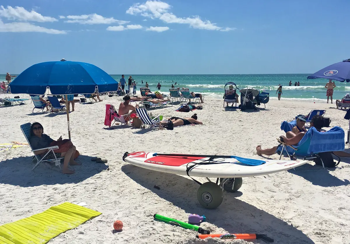 Paddleboard and umbrellas on the sand at a busy Crescent Beach