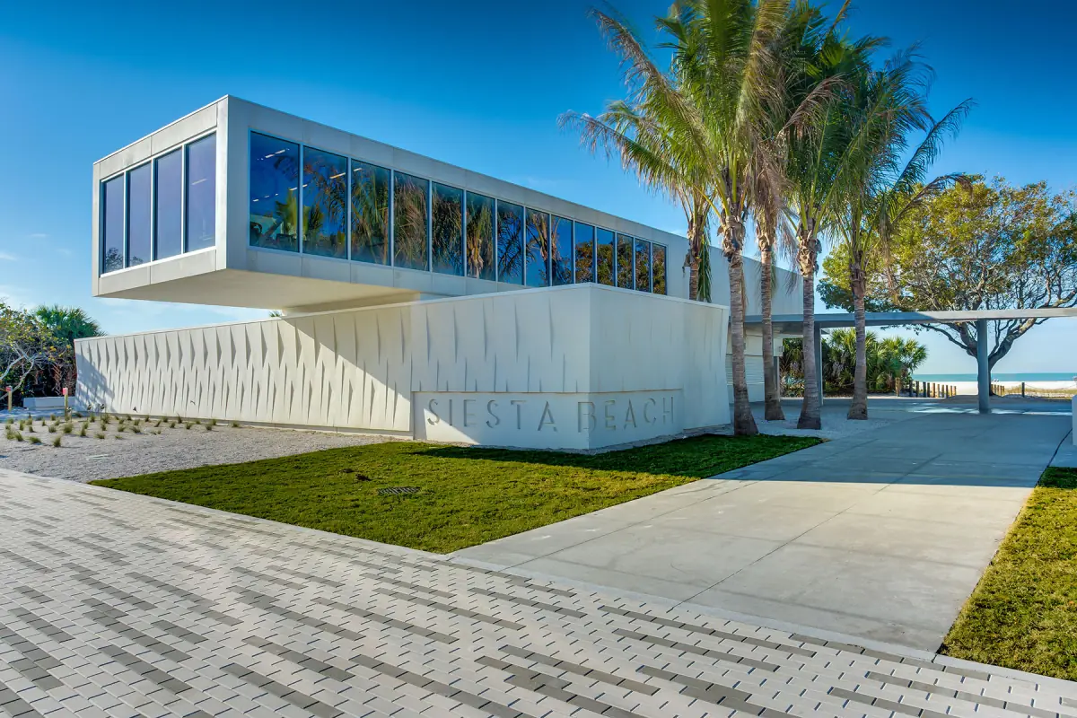 Modern white pavilion with large windows and palm trees at Siesta Key Beach